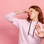 eine Frau die riecht stinkendes Darmgas und ist damit seht unzufrieden